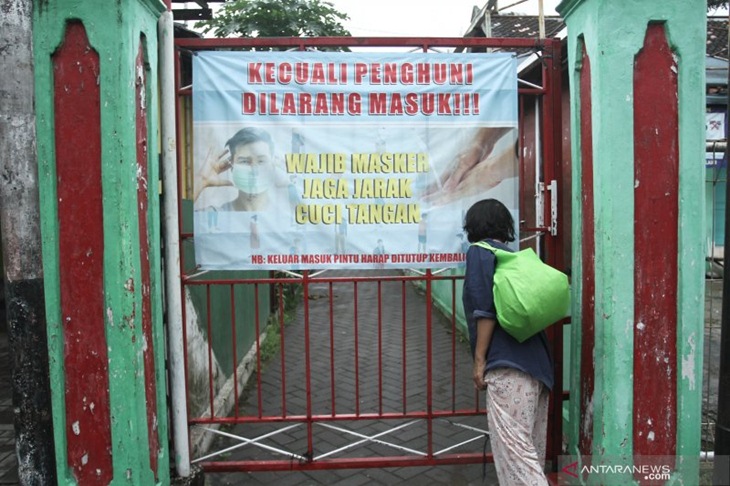 Warga keluar dari gang kampung yang dipasangi poster imbauan memakai masker di Gunungketur, Pakualaman, Yogyakarta, Senin (8/2/2021). Pemerintah Daerah Istimewa Yogyakarta memperpanjang Pemberlakuan Pembatasan Kegiatan Masyarakat (PPKM) hingga tanggal 23 Februari 2021 sesuai arahan Presiden Joko Widodo untuk mengoptimalkan pengawasan pengetatan berskala mikro, yakni memotong penularan COVID-19 di level pedukuhan, kelurahan, RT dan RW. (ANTARA FOTO/Hendra Nurdiyansyah/foc)