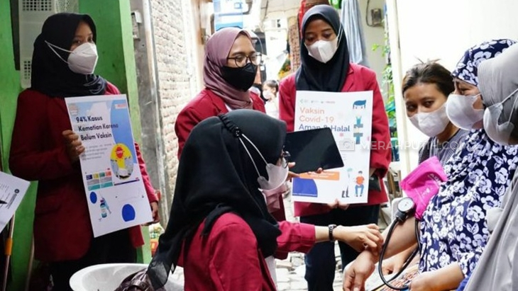 Para mahasiswa Universitas Muhammadiyah Surabaya (UMS) mengawal warga untuk mendaftarkan vaksin via online. (Foto: MP/Don)