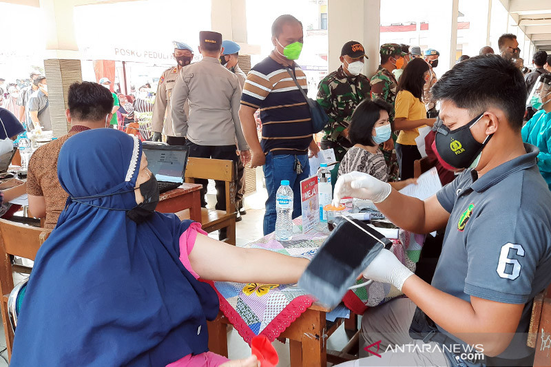 Petugas kesehatan memeriksa dokumen warga yang akan menerima vaksin COVID-19 di SDN 01 Klender, Jakarta, Rabu (28/7/2021). ANTARA/Yogi Rachman