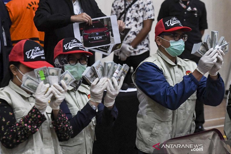 Penyidik KPK menunjukan barang bukti uang tunai saat konferensi pers terkait Operasi Tangkap Tangan (OTT) tindak pidana korupsi pada program bantuan sosial di Kementerian Sosial untuk penanganan COVID-19 di Gedung KPK, Jakarta, Minggu (6/12/2020) dini hari. Dalam operasi tangkap tangan itu KPK menetapkan lima tersangka yakni Menteri Sosial Juliari P Batubara, pejabat pembuat komitmen di Kemensos Matheus Joko Santoso dan Adi Wahyono dan pihak swasta Ardian IM dan Harry Sidabuke serta mengamankan uang dengan jumlah Rp14,5 miliar. ANTARA FOTO/Hafidz Mubarak A/pras