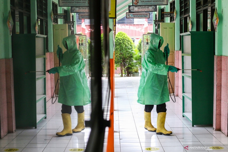 Petugas menyemprotkan cairan disinfektan di area SDN Kebayoran Lama Selatan 17 Pagi, Jakarta, Rabu (25/8/2021). Pemerintah Provinsi (Pemprov) DKI Jakarta berencana membuka sekolah untuk menggelar pembelajaran tatap muka (PTM) terbatas pada Senin 30 Agustus 2021. ANTARA FOTO/Rivan Awal Lingga/foc.