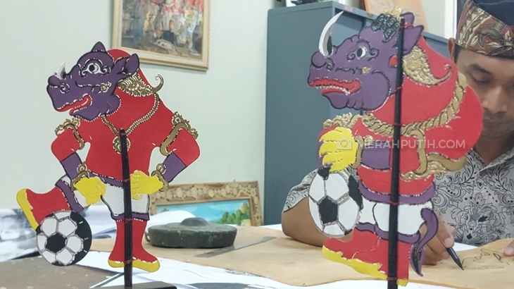 Perajin wayang kulit Sanggar Wayang Gogon, Margono (44) menunjukkan souvenir Piala Dunia U-20, Kamis (30/3). (MP/Ismail)