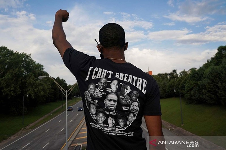 Seorang warga memakai kaos dengan nama dan wajah orang kulit hitam yang ditembak oleh polisi mengacungkan kepalan tangannya dalam acara Juneteenth, yang memperingati berakhirnya perbudakan di Texas, dua tahun setelah Proklamasi Emansipasi 1863 membebaskan budak di seluruh Amerika Serikat, di tengah protes secara nasional atas ketidakadilan rasial, di Atlanta, Georgia, Amerika Serikat, Jumat (19/6/2020). ANTARA FOTO/REUTERS/Elijah Nouvelage/aww/cfo