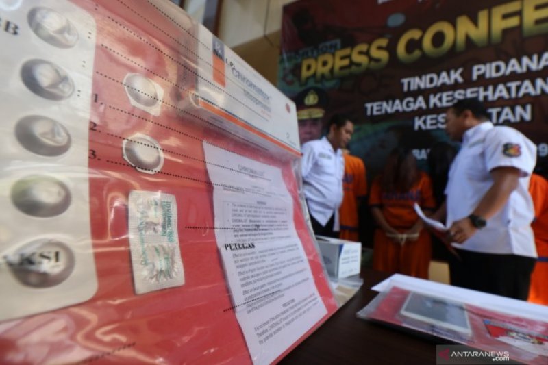 Polisi menunjukkan barang bukti dan tersangka saat ungkap kasus praktik aborsi ilegal di Polda Jawa Timur, Surabaya, Jawa Timur, Selasa (25/6/2019). (Foto Didik Suhartono)	