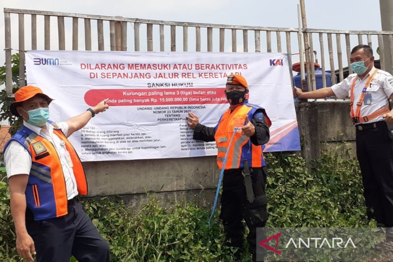 Petugas PT KAI memasang spanduk larangan beraktivitas di sekitar rel kereta api. (ANTARA/HO-PT KAI Daop 2)