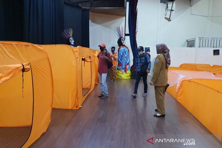 Lurah Kebon Melati Winetrin mengantarkan warganya pemilik hasil 'rapid test' reaktif untuk memilih bilik isolasi mandiri sementara, di Balai Latihan Kesenian Jakarta Pusat, Senin (18/5/2020) (ANTARA/Livia Kristianti)
