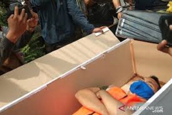 Seorang pelanggar protokol kesehatan di Kecamatan Pasar Rebo, Jakarta Timur, menjalani sanksi merenung di dalam peti jenazah usai terjaring razia petugas di Jalan Raya Bogor, Kamis (3/9/2020). (ANTARA/Andi Firdaus)