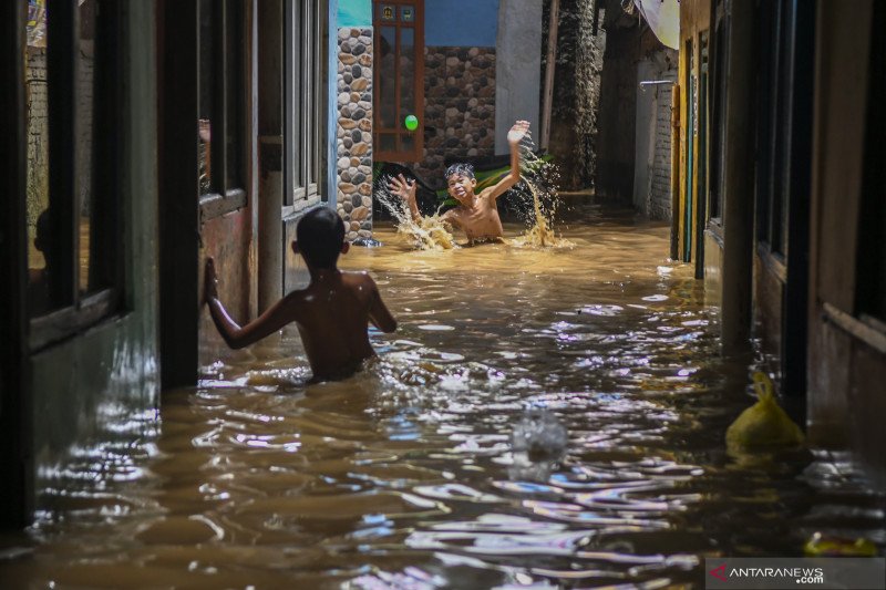 Sejumlah anak bermain ketika banjir di Kebon Pala, Jatinegara, Selasa (22/9/2020). Banjir tersebut terjadi karena luapan Sungai Ciliwung. (ANTARA FOTO/Galih Pradipta/wsj)