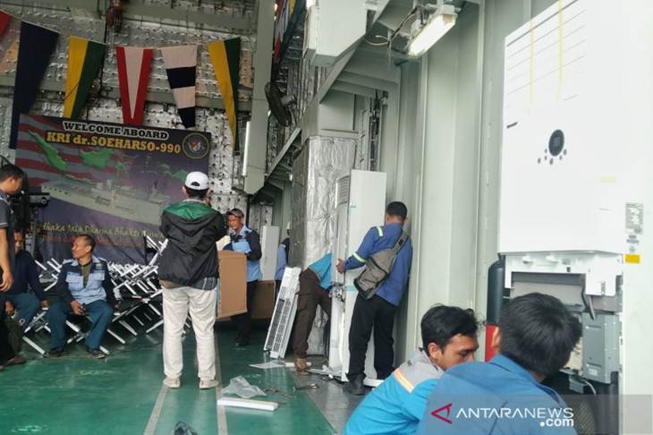 Sejumlah petugas tengah memasang instalasi pendingin ruangan di deck KRI dr Soeharso yang bersandar di Dermaga Komando Armada II Surabaya, Kamis (20/2/2020). (ANTARA/Aditya Ramadhan)