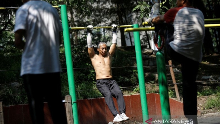 Seorang pria berlatih di taman, Beijing, setelah kebijakan "bebas masker". REUTERS/Tingshu Wang/PRAS/djo