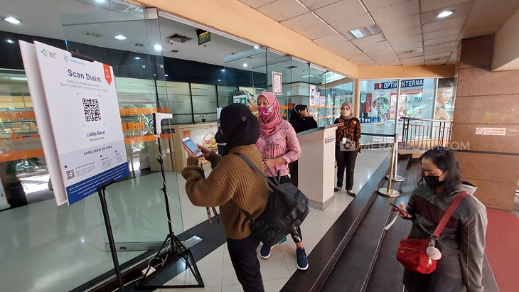 Pengunjung memanfaatkan aplikasi PeduliLindungi saat masuk ke Solo Grand Mal. (MP/Ismail)