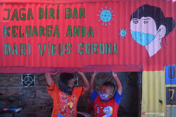 Anak-anak bermain di samping mural tentang pencegahan COVID-19 di Jakarta, Senin (27/7/2020). ANTARA FOTO/Akbar Nugroho Gumay/pras.