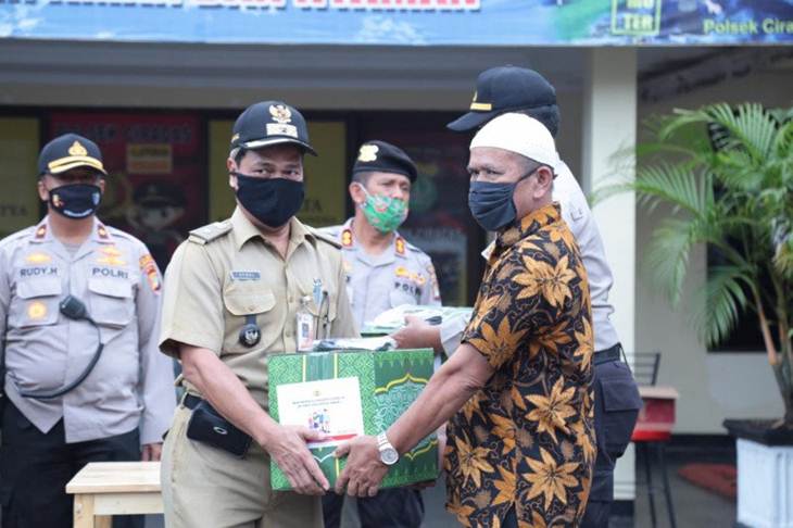 Petugas Kelurahan Cakung Barat memberikan bantuan sembako kepada warga di wilayah setempat, Selasa (14/4/2020). Bantuan disalurkan dalam rangka membantu kesulitan ekonomi masyarakat di tengah wabah COVID-19. (ANTARA/HO-Humas Polrestro Jaktim).