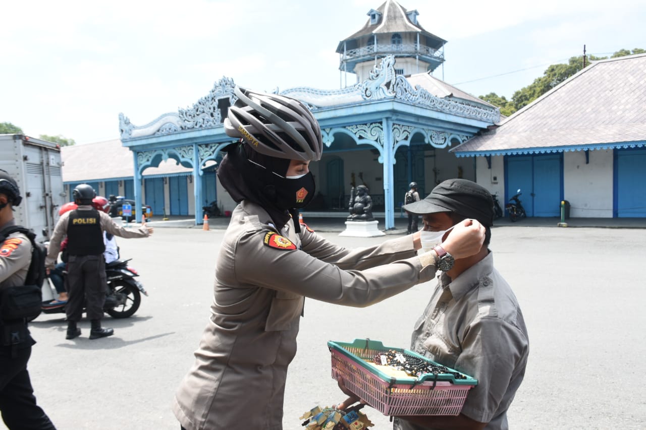  Polwan Polresta Surakarta, Jawa Tengah membagikan masker di pada warga. (MP/Ismail)