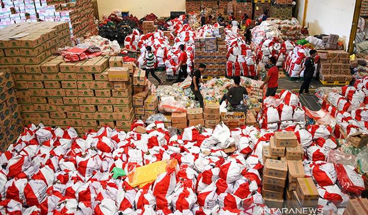 Pekerja mengemas paket bantuan sosial (bansos) di Gudang Food Station Cipinang, Jakarta, Rabu (22/4/2020). (ANTARA FOTO/M RISYAL HIDAYAT)