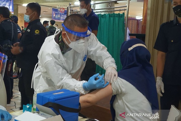 Tenaga kesehatan dari TNI melakukan vaksinasi kepada pedagang dalam acara vaksinasi massal pedagang di Blok A Pasar Tanah, Jakarta Pusat, Rabu (17/2/2021). (ANTARA/Livia Kristianti)