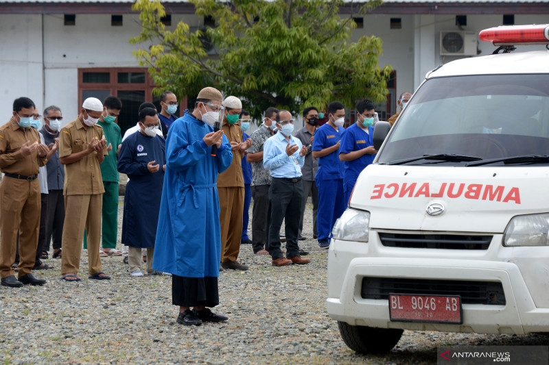 Sejumlah dokter bersama tenaga medis lainnya melaksanakan shalat jenazah untuk dokter spesialis paru yang positif COVID-19 saat pelepasan terakhir menggunakan mobil ambulans ke pemakaman di Rumah Sakit Umum Zainainal Abidin, Banda Aceh, Aceh, Selasa. ANTARA FOTO/Ampelsa