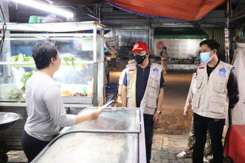 Tim Satgas Kota Bandarlampung sedang melakukan kegiatan sosialisasi PPKM dan juga penegakkan prokes ke sejumlah pedagang yang masih membuka usahanya melebihi jam operasional yang telah ditentukan. Selasa malam, (29/6/2021). (ANTARA/Dian Hadiyatna)