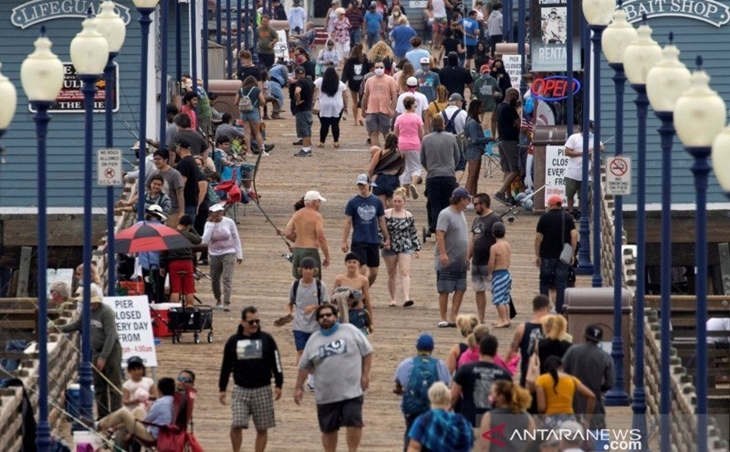 Beberapa orang dengan memakai masker berjalan di dermaga di Oceanside, California, Amerika Serikat, Senin (22/6/2020. (ANTARA FOTO/REUTERS/Mike Blake/foc/djo)