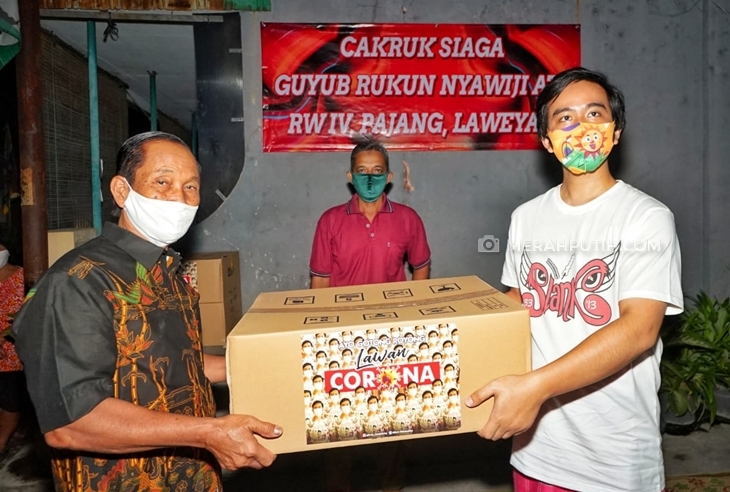 Gibran Rakabuming Raka menyerahkan bantuan pada warga terdampak virus corona. (MP/Ismail)