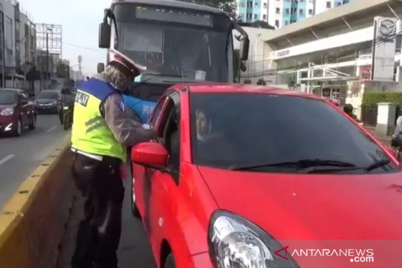 Polisi lalu lintas menilang pengendara mobil yang melintasi di jalur TransJakarta Jalan Raya Jatinegara Barat, Jakarta Timur, Jumat (24/7/2020). Sedikitnya 40 pengendara ditilang kurang dari satu jam Operasi Patuh Jaya 2020. (ANTARA/Andi Firdaus)