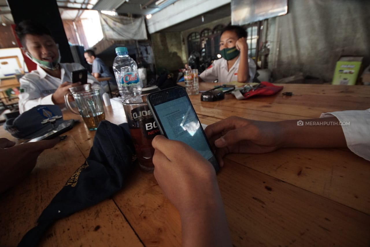 Siswa SD sedang menerima materi dari sekolah dikerjakan dengan metode daring di warkop Ijo, Sidoarjo, Jawa Timur. Foto: MP/Andika Eldon