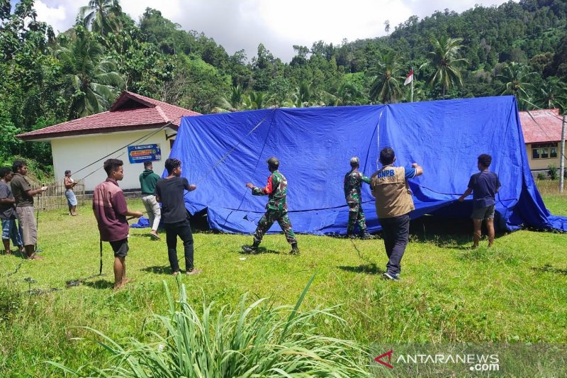 Petugas BPBD bersama personel TNI dan warga memasang tenda darurat untuk pengungsi di Tehoru, Kabupaten Maluku Tengah, Kamis (17/6). Gempa berkekuatan magnitudo 6.1 pada 16 Juni 2021 menyebabkan 7.227 warga dari empat negeri mengungsikan diri. (HO/BPBD Malteng)