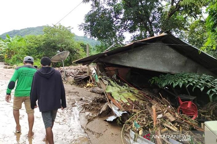 Warga melintas di dekat rumah yang rusak akibat banjir bandang di Adonara Timur, Flores Timur, NTT, Senin (5/4/2021). ANTARA FOTO/Pion Ratuloli/wpa/wsj.