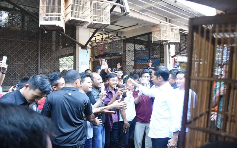 Selain blusukan ke Pasar Burung Depok, Solo, Presiden Jokowi juga membagikan sarung kepada warga