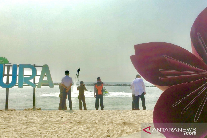Bupati Kepulauan Seribu Junaedi (mengenakan rompi) menyaksikan atraksi ‘flyboard’ atau papan terbang di atas air saat berkunjung ke destinasi wisata Pantai Sakura di Pulau Untung Jawa, Kepulauan Seribu Selatan pada Senin (24/5/2021). (ANTARA/Abdu Faisal)