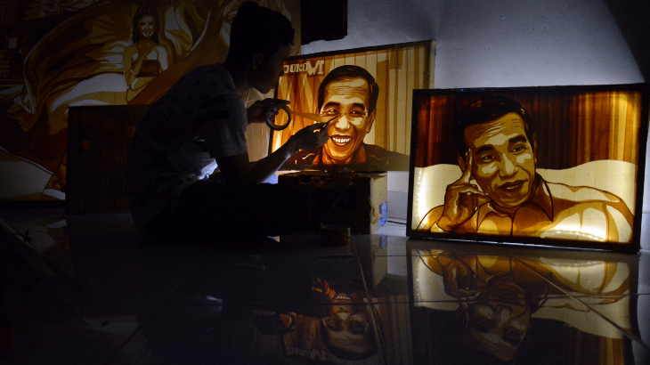 Seniman Dede Rai Nida Pradnyana menyelesaikan hasil karya lukisan Presiden Jokowi berbahan dasar selotip di Denpasar, Selasa (20/6). Seniman Dede Rai Nida sengaja membuat lukisan tersebut sebagai hadiah ulang tahun Presiden Jokowi ke-56 pada 21 Juni 2017. ANTARA FOTO/Wira Suryantala/foc/17.