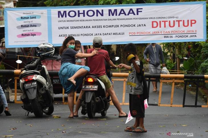 Warga turun dari motornya saat pemberlakuan penutupan akses wilayah di Komplek Pondok Jaya, Jakarta Selatan, Senin (30/3/2020). ANTARA FOTO/Indrianto Eko Suwarso/foc.
