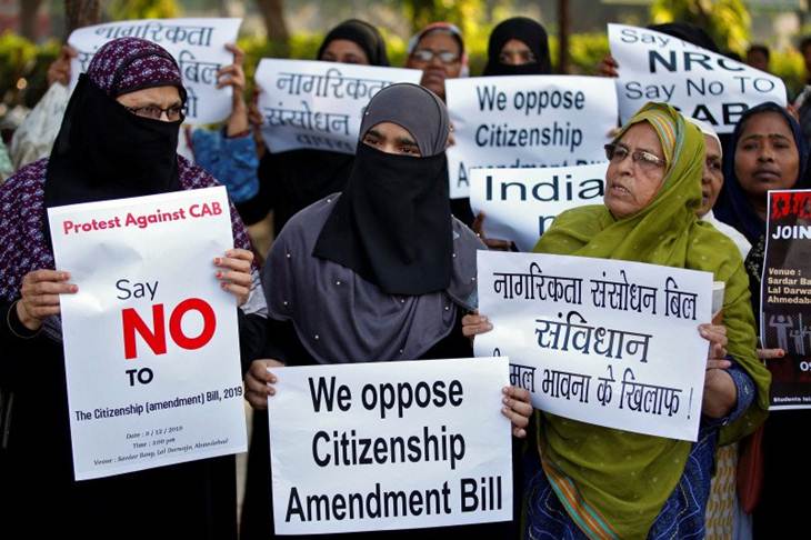 Pengunjuk rasa membawa poster saat protes atas RUU Perubahan Kewarganegaraan, sebuah ruu yang memberikan kewarganegaraan kepada warga dengan agama minoritas yang dianiaya di negara Muslim tetangga, di Ahmedabad, India, Senin (9/12/2019). (REUTERS/AMIT DAVE)