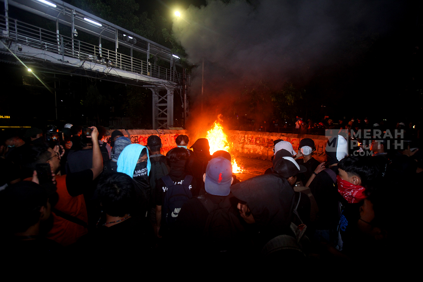 Aksi mahasiswa melempar batu ke arah polisi dalam aksi demo Indonesia Gelap di Patung Kuda, Silang Monas, Jakarta, Jum'at (21/2/2025).