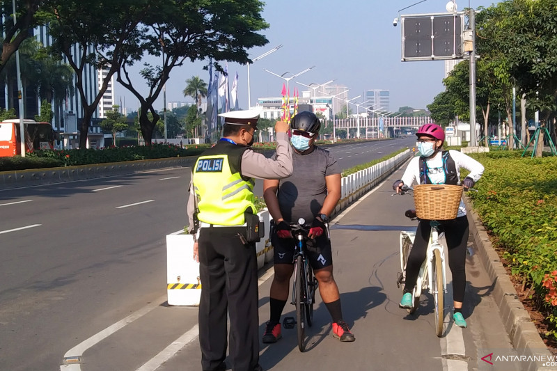 Polisi menghalau pesepeda di kawasan Jalan Sudirman di dekat Gelora Bung Karno (GBK) karena pembatasan mobilitas saat PPKM Darurat, Jakarta, Sabtu (3/7/2021). ANTARA/Dewa Ketut Sudiarta Wiguna