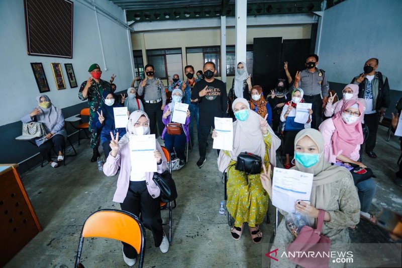 Sejumlah pendidik dan tenaga kependidikan (PTK) menunjukkan kartu hasil vaksinasi COVID-19 di Bandung, Jawa Barat, Sabtu (29/5/2021). (ANTARA/HO-Humas Pemkot Bandung)