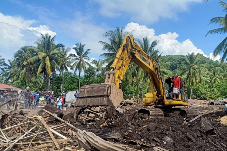 Alat eksavator mengangkut material puing bangunan dan batu yang mengubur Desa Lamanele, Adonara Timur, NTT, Kamis (8/4/2021). (ANTARA/Andi Firdaus)