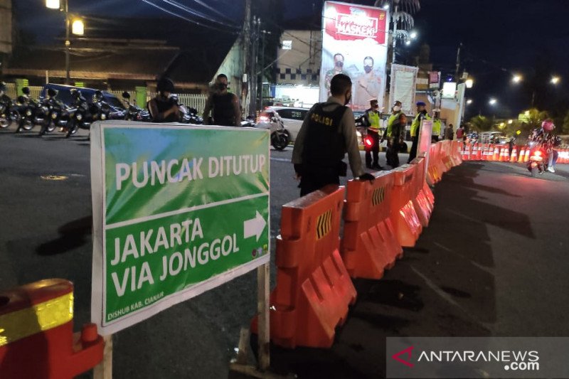 Tepat pukul 18.00 WIB Kamis (31/12) anggota Polres Cianjur, Jawa Barat, menutup jalur menuju Puncak-Cipanas, mulai dari bundaran Tugu Lampu Gentur-By Pass, Cianjur, sebagai upaya memutus antrian kendaraan menjelang malam pergantian tahun. ANTARA/Ahmad Fikri