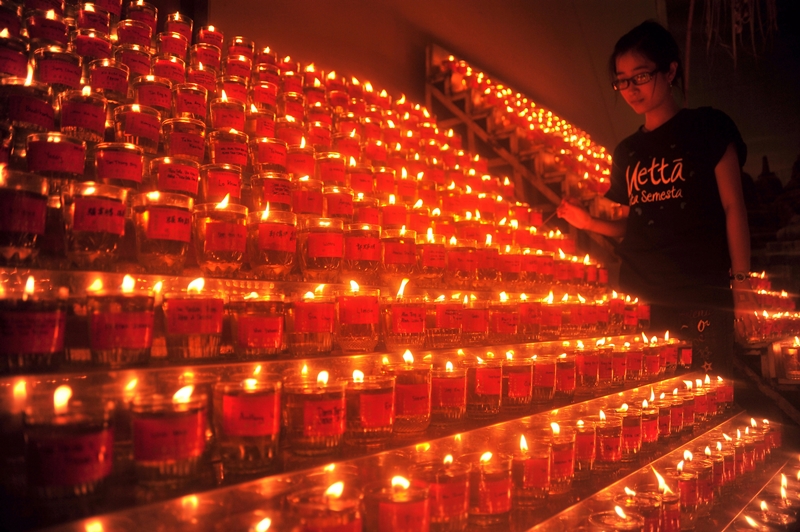 Seorang gadis menyalakan lilin sebagai rangkaian perayaan Waisak di Vihara Dharmakirti Palembang, Sumsel, Senin (1/6). ANTARA FOTO/Feny Selly