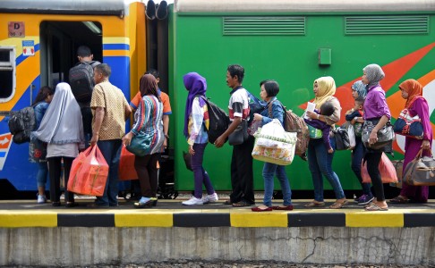 Penumpang antre menaiki gerbong kereta api KRD Surabaya-Bojonegoro di Stasiun Pasar Turi, Surabaya, Jawa Timur, Rabu (15/7). Menurut data Kepala Stasiun Pasar Turi Sigit Setiadi Prabowo, pada H-2 Lebaran peningkatan pemudik mencapai 7.500 sampai 8.000 penumpang.