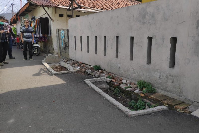 Warga melintas di dekat makam yang berada di jalan umum kawasan Pisangan Lama, Jakarta Timur, Selasa (16/6/2020). Warga setempat menyebutkan makam keluarga itu ada sejak 1940. (ANTARA/HO-Kelurahan Pisangan Timur)