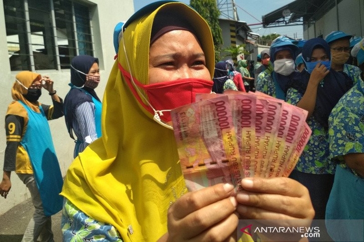 Ilustrasi - Seorang pekerja di Kabupaten Kudus, Jawa Tengah, menunjukkan uang tunjangan hari raya (THR). (ANTARA/Akhmad Nazaruddin Lathif)