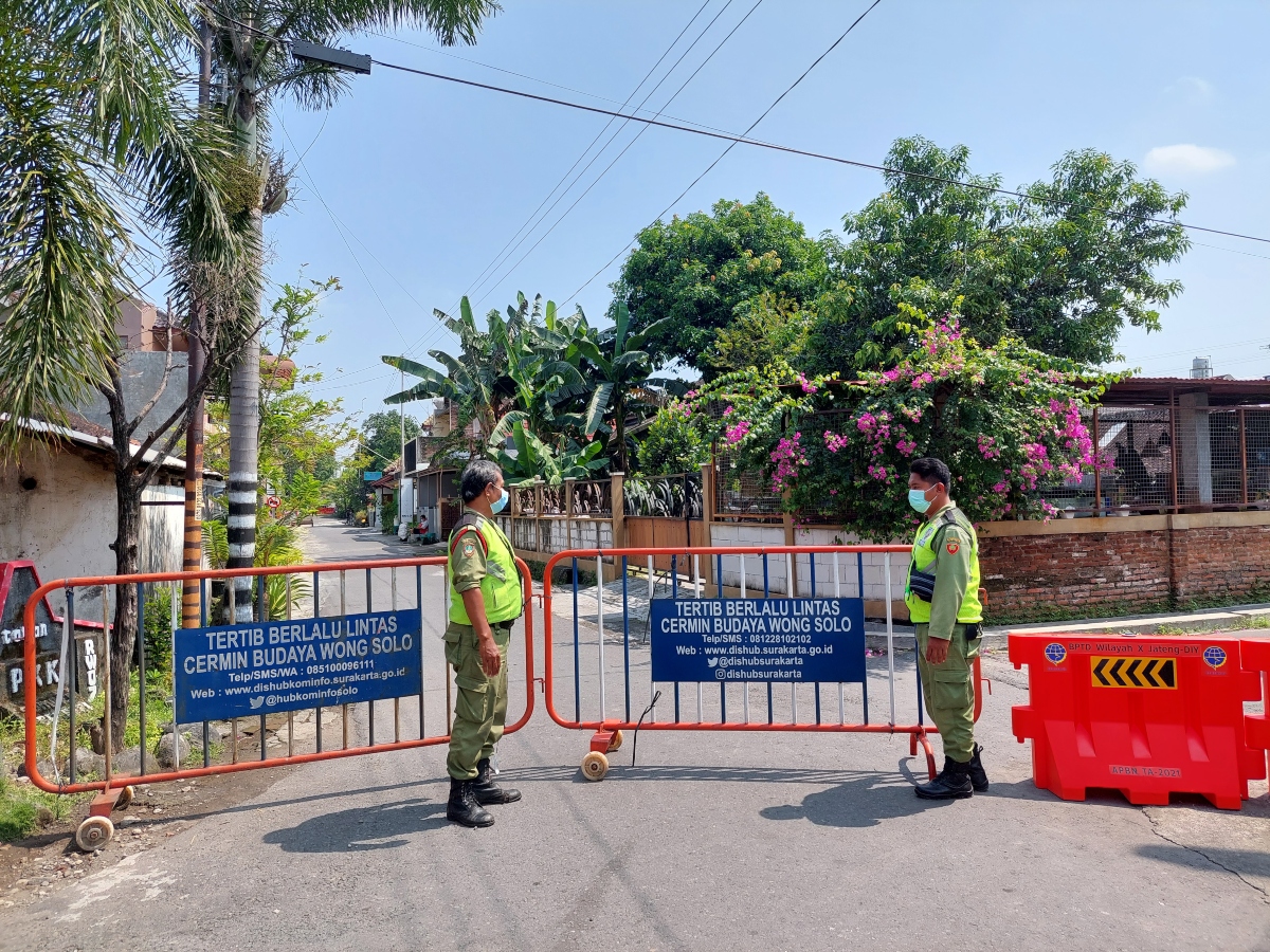 Petugas Linmas berjaga di jalan masuk kampung rumah warga yang jalani karantina wilayah, Sabtu (22/5). (MP/Ismail)