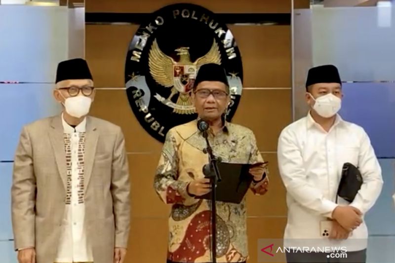 Ketua Majelis Ulama Indonesia (MUI) Miftachul Akhyar (kiri) berdiri di samping Menko Polhukam Mahfud MD (tengah) saat jumpa pers di Kantor Kemenko Polhukam, Jakarta, Senin (22/11/2021), sebagaimana disiarkan oleh kanal YouTube Kemenko Polhukam RI. ANTARA/Genta Tenri Mawangi