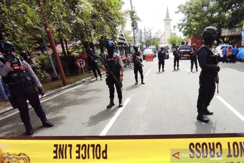 Polisi bersenjata lengkap mengamankan lokasi setelah ledakan bom bunuh diri di gerbang Gereja Katedral, di Jalan Kajaolalido, Kecamatan Ujungpandang, Kota Makassar, Sulawesi Selatan, Minggu (28/3/2021). (ANTARA)