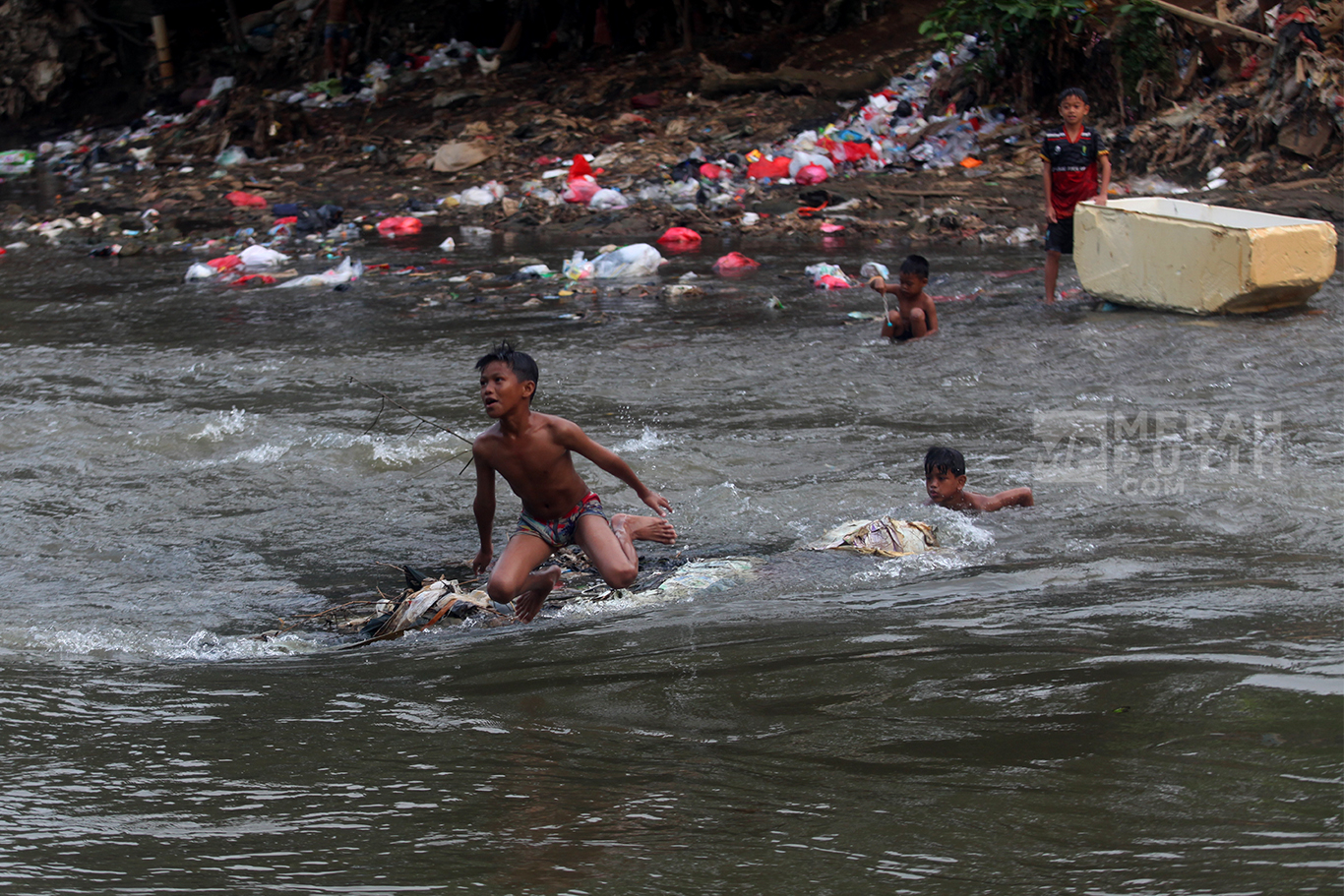 Mengintip Keseruan Anak-anak Bermain Air Aliran Sungai Ciliwung Jakarta