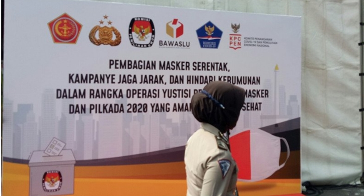 Personel Kepolisian melintas di depan banner kegiatan pembagian masker di Polda Metro Jaya Kamis (10/9/2020). Polda Metro Jaya membagikan lima juta masker secara serentak di seluruh wilayah hukumnya yakni Jakarta, Bekasi, Depok dan Tangerang serta mengampanyekan protokol kesehatan menjelang Pilkada 2020. ANTARA/Fianda Sjofjan Rassat