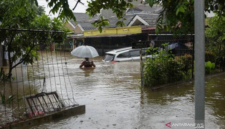 Warga berjalan melintasi banjir di Bekasi, Jawa Barat, Rabu (1/1/2020). Banjir juga merendam bangunan sekolah di wilayah tersebut. ANTARA/Paramayuda/foc.