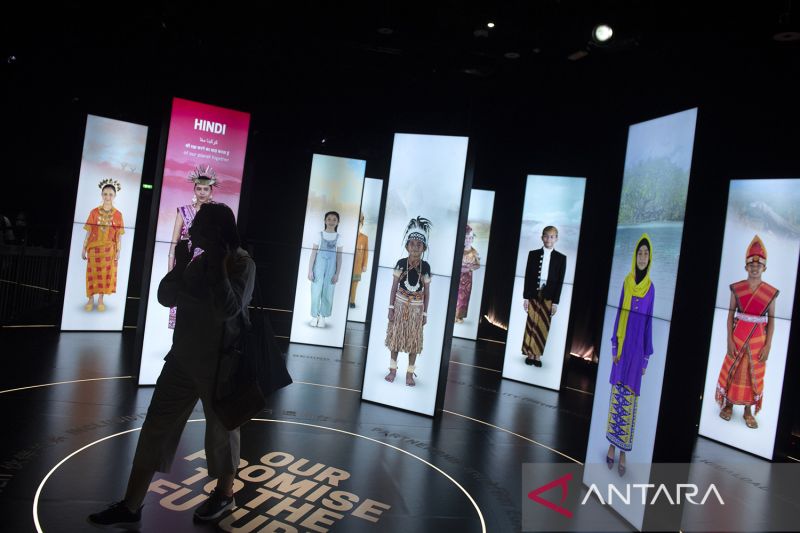 Pengunjung menyaksikan video pakaian adat di area Paviliun Indonesia saat Dubai Expo 2020, Uni Emirat Arab, Jumat (11/3/2022).