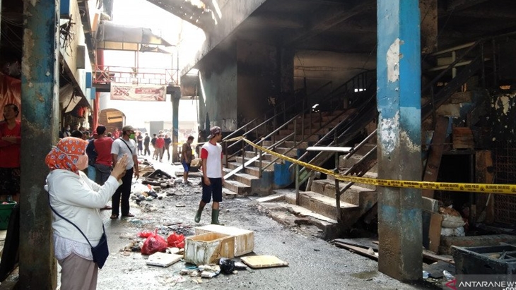 Warga mengamati puing yang hangus terbakar di Blok C Pasar Inpres Pasar Minggu, Jakarta Selatan, Selasa (13/4/2021). ANTARA/Dewa Wiguna.
